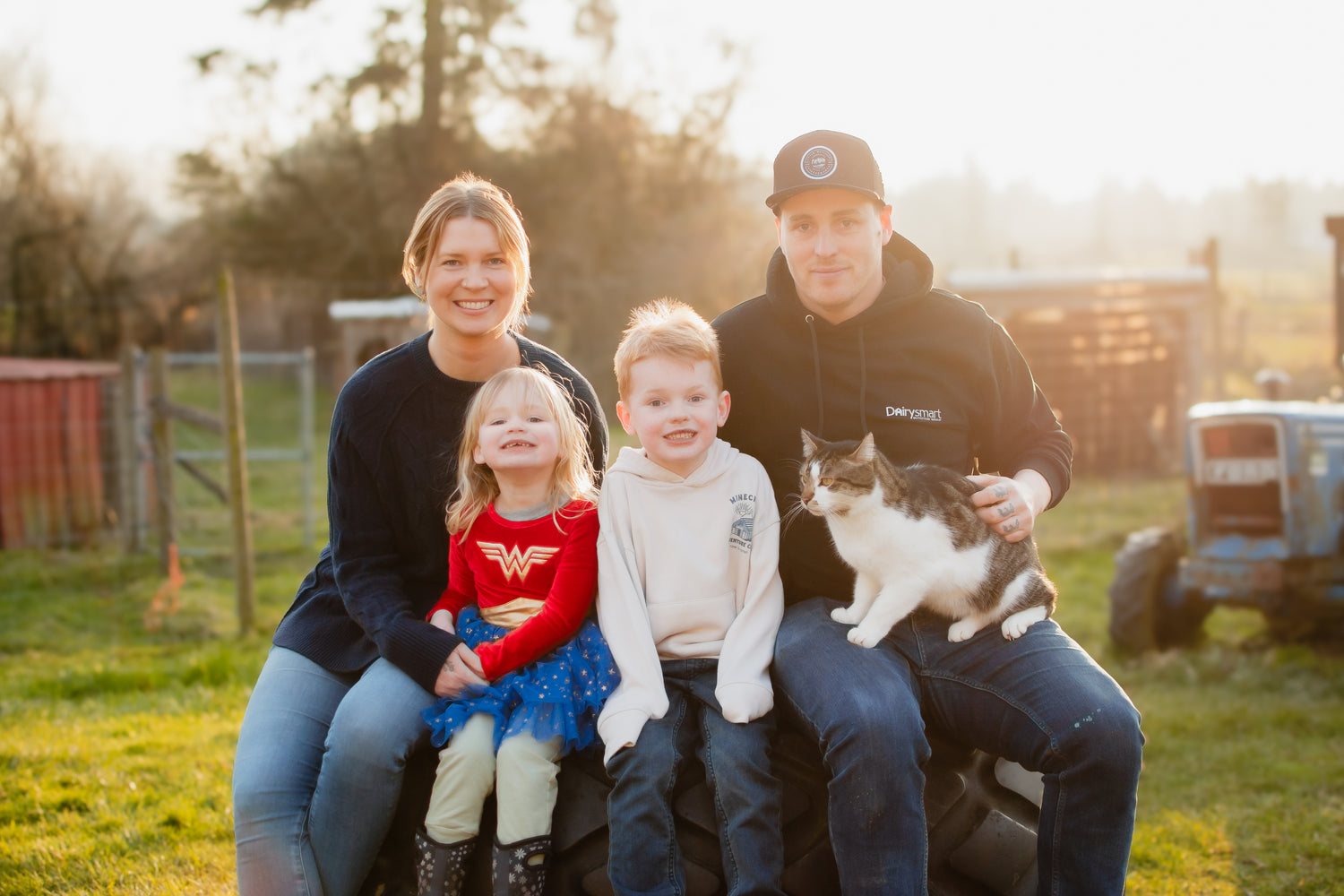 Chelsea and Albert with family and tractor and sun and farmland behind them