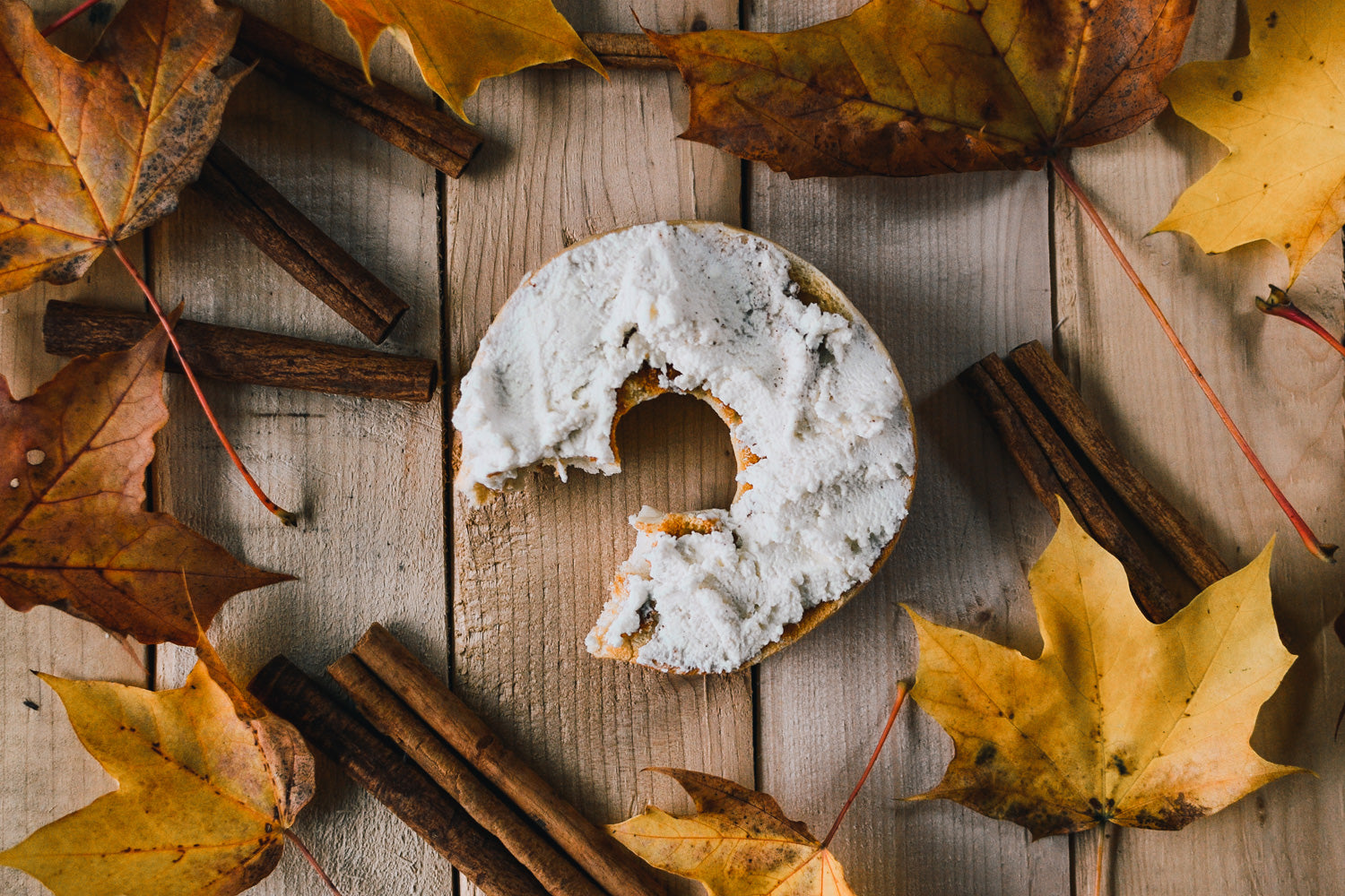 Maple Cinnamon Fromage Frais, served on a bagel and styled with cinnamon sticks and maple leaves.