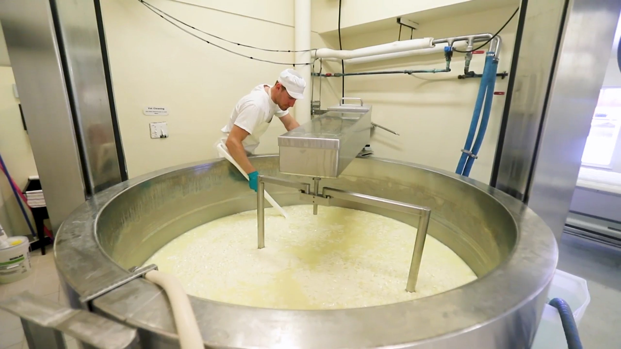 Worker tending to vat being mixed with ingredients