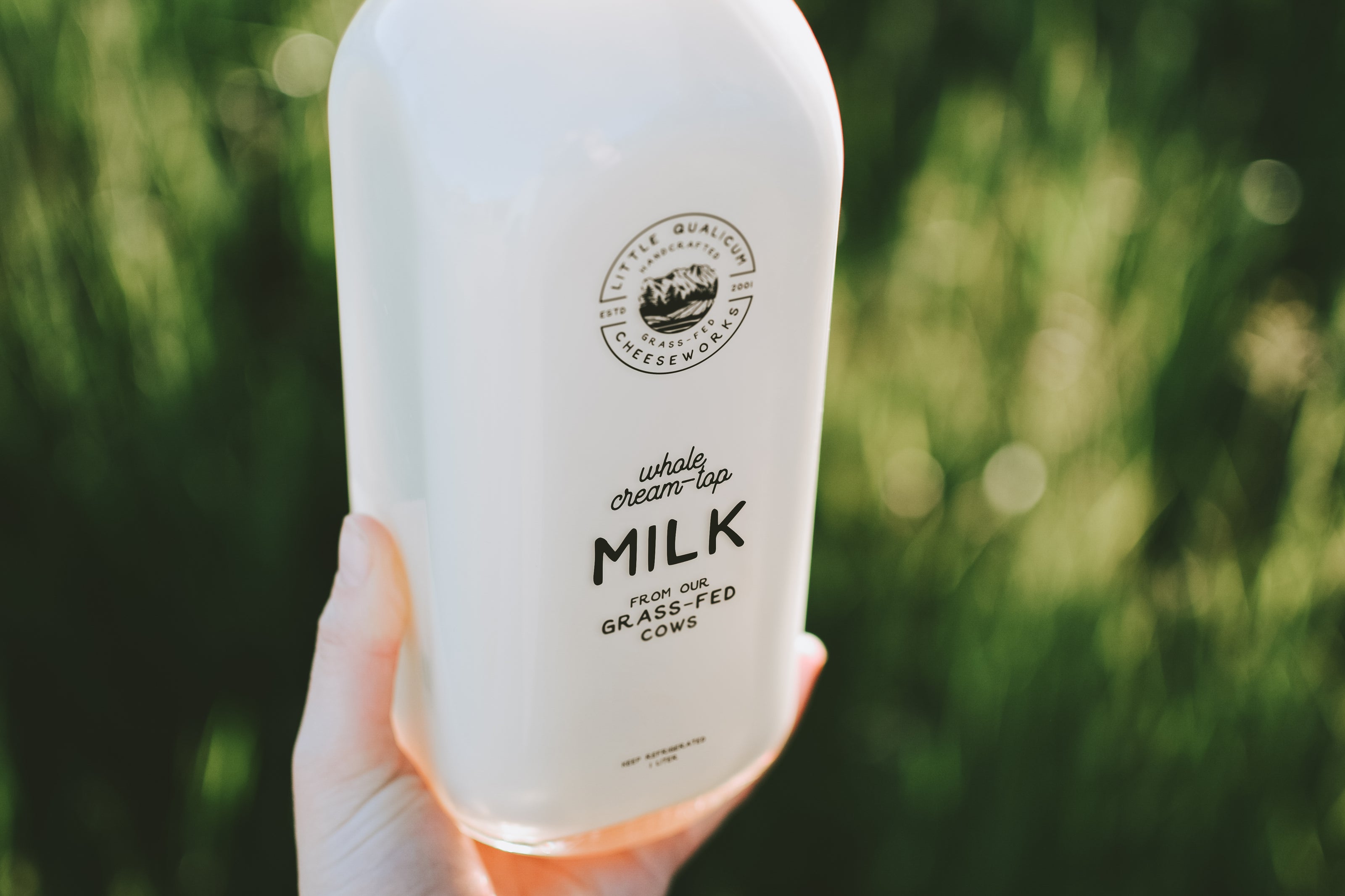 Filled milk bottle held by customer