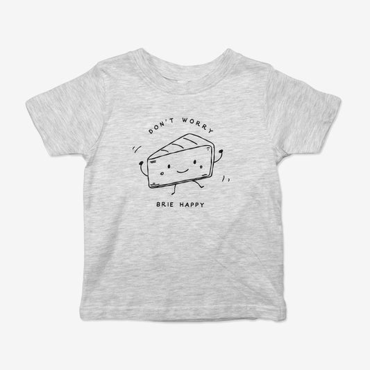 Front view of Little Qualicum Cheeseworks' children's t-shirt in heathered ash featuring a line-drawing graphic of a cute dancing Brie and the text "Don't worry, Brie happy"