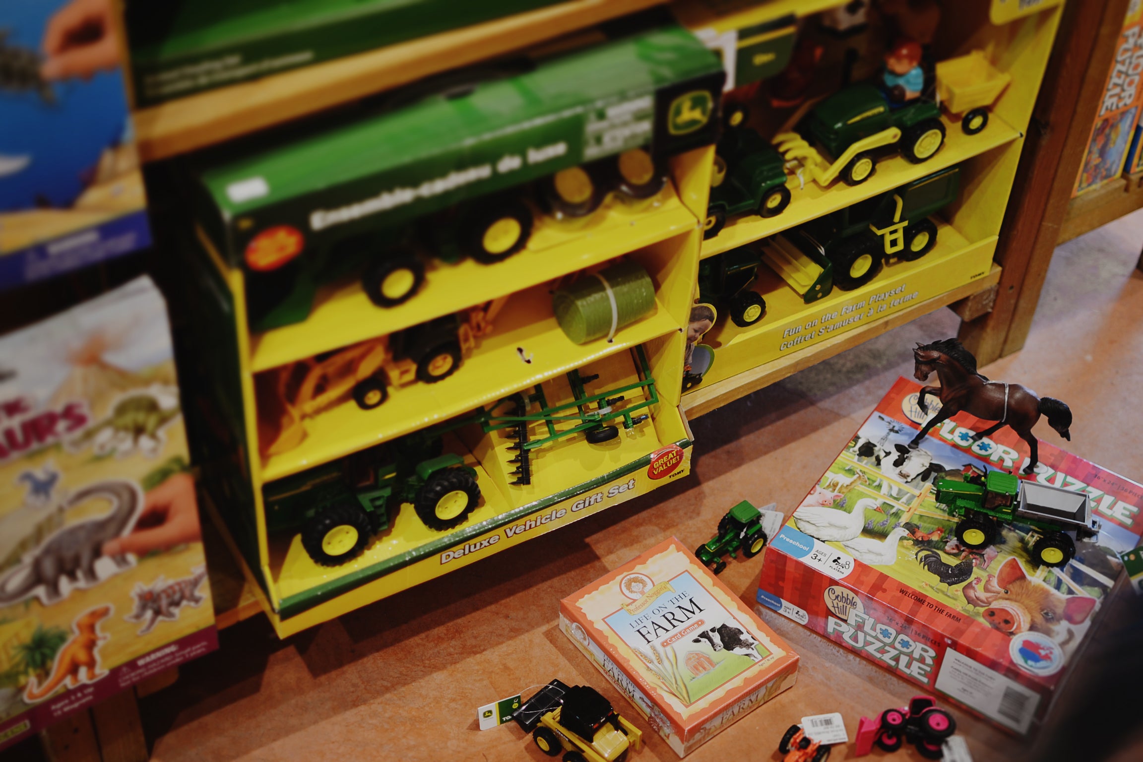 Farm-themed toys including John Deere tractors, farm animals, and games