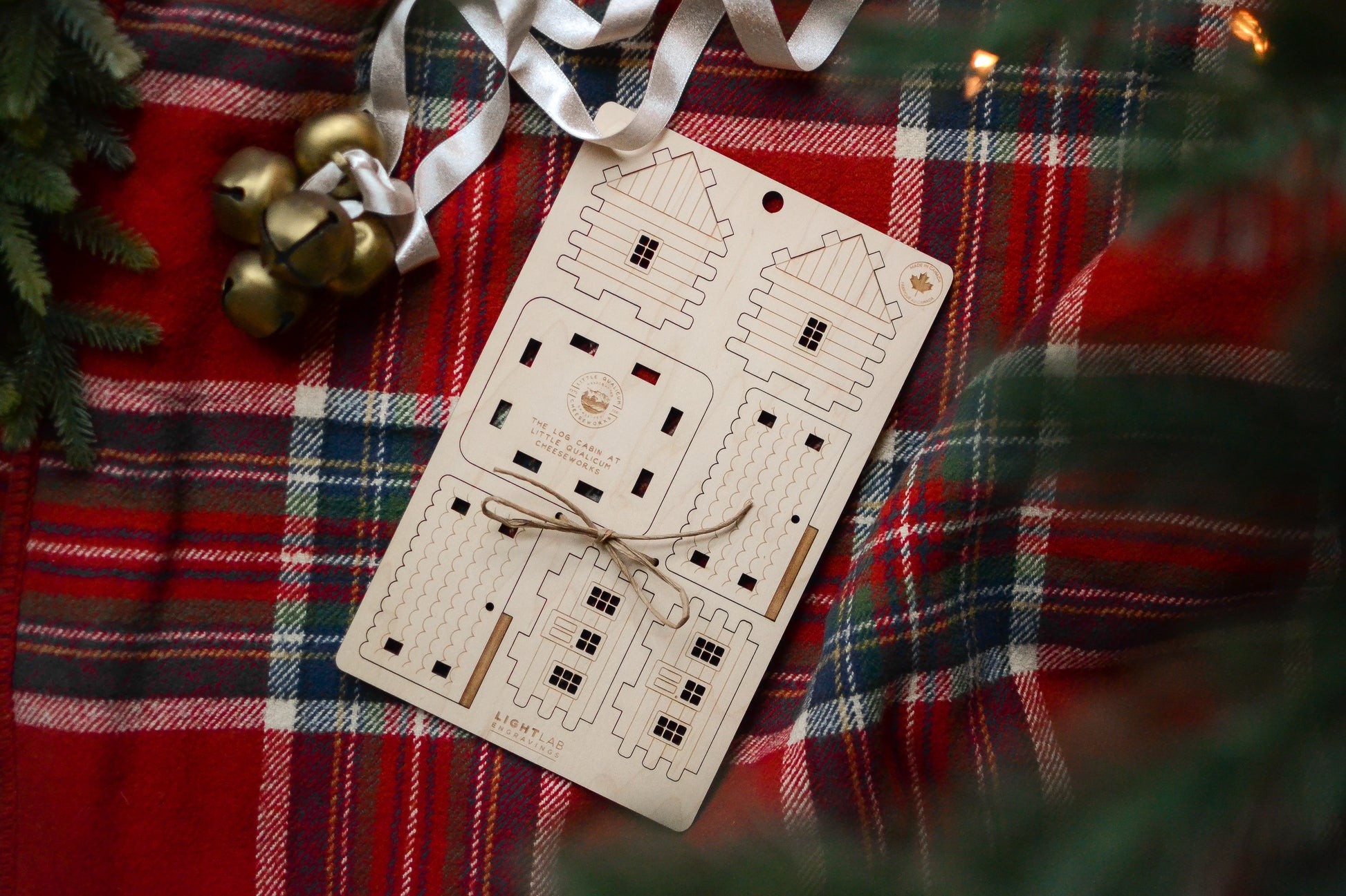 The un-assembled cabin is styled under a Christmas tree.