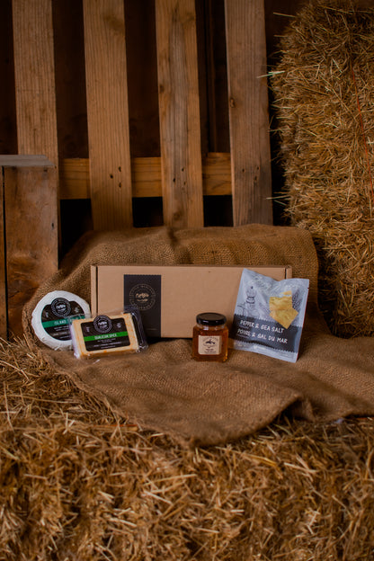 Customizable gift box with cheese pairing items on a rustic wooden background