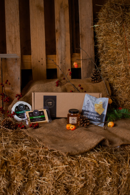Customizable gift box with cheese pairing items on a rustic wooden background