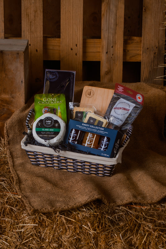 A cheese lover's gift basket with cheese various BC local food pairings on a rustic wooden background
