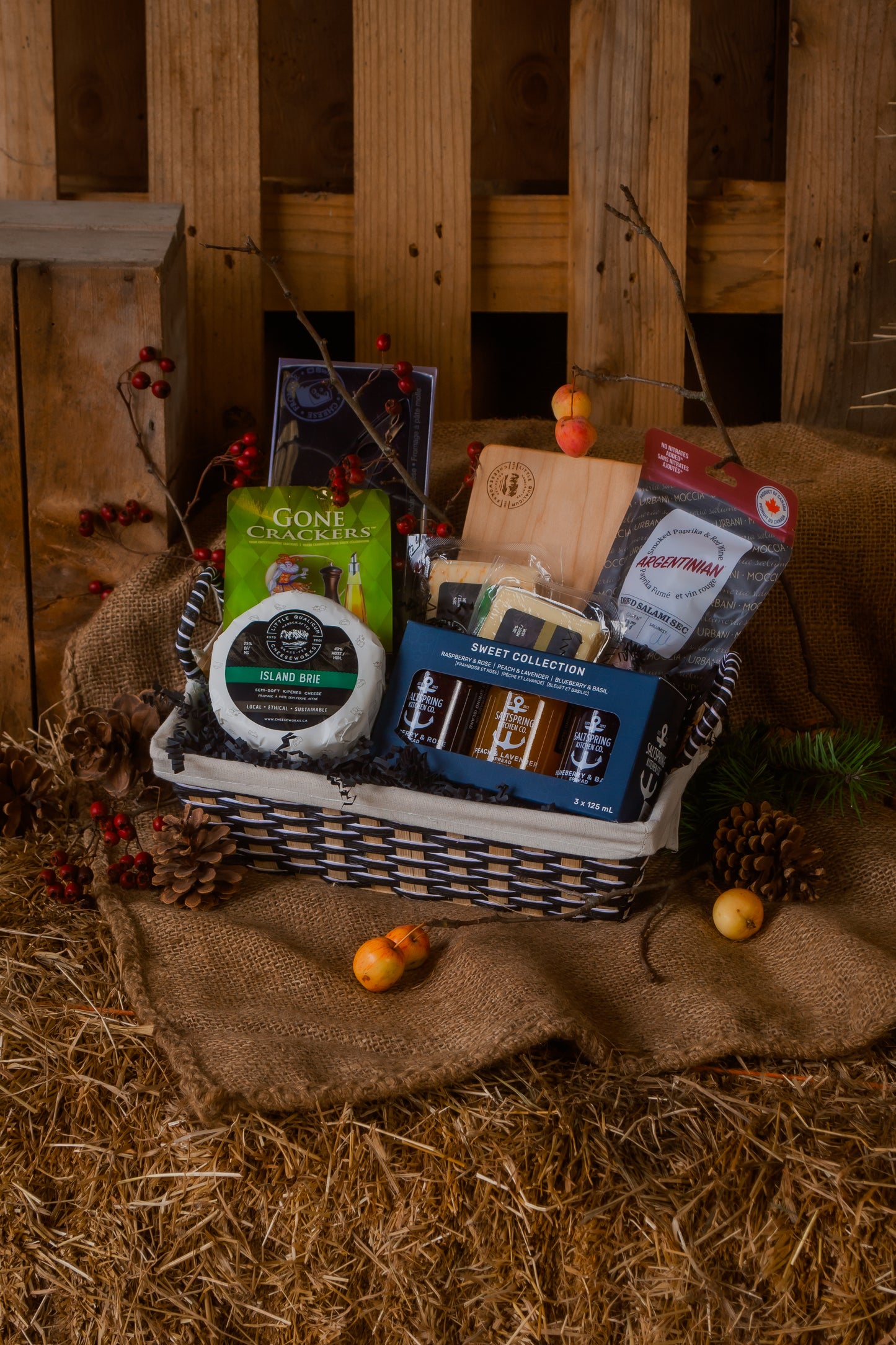A cheese lover's gift basket with cheese various BC local food pairings on a rustic wooden background