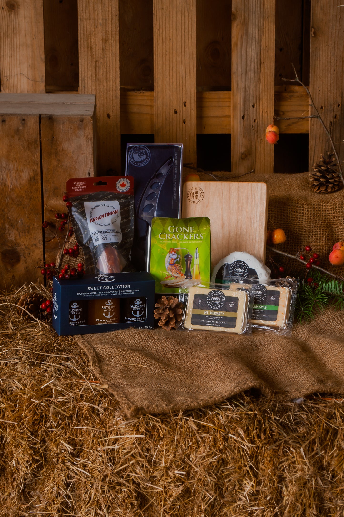 Assorted food products including cheese and crackers on a rustic wooden background with Christmas decorations