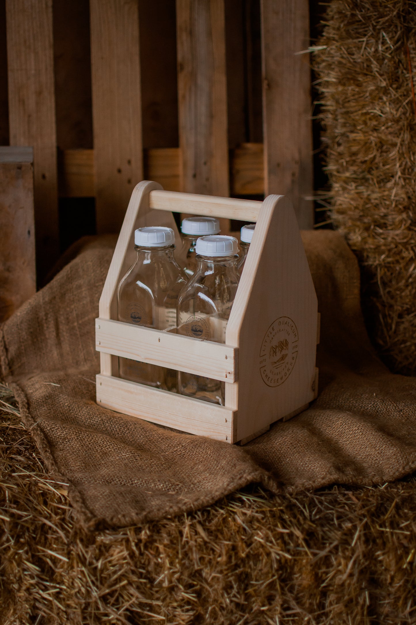 Medium sized wooden bottle carrier with glass bottles on a rustic background