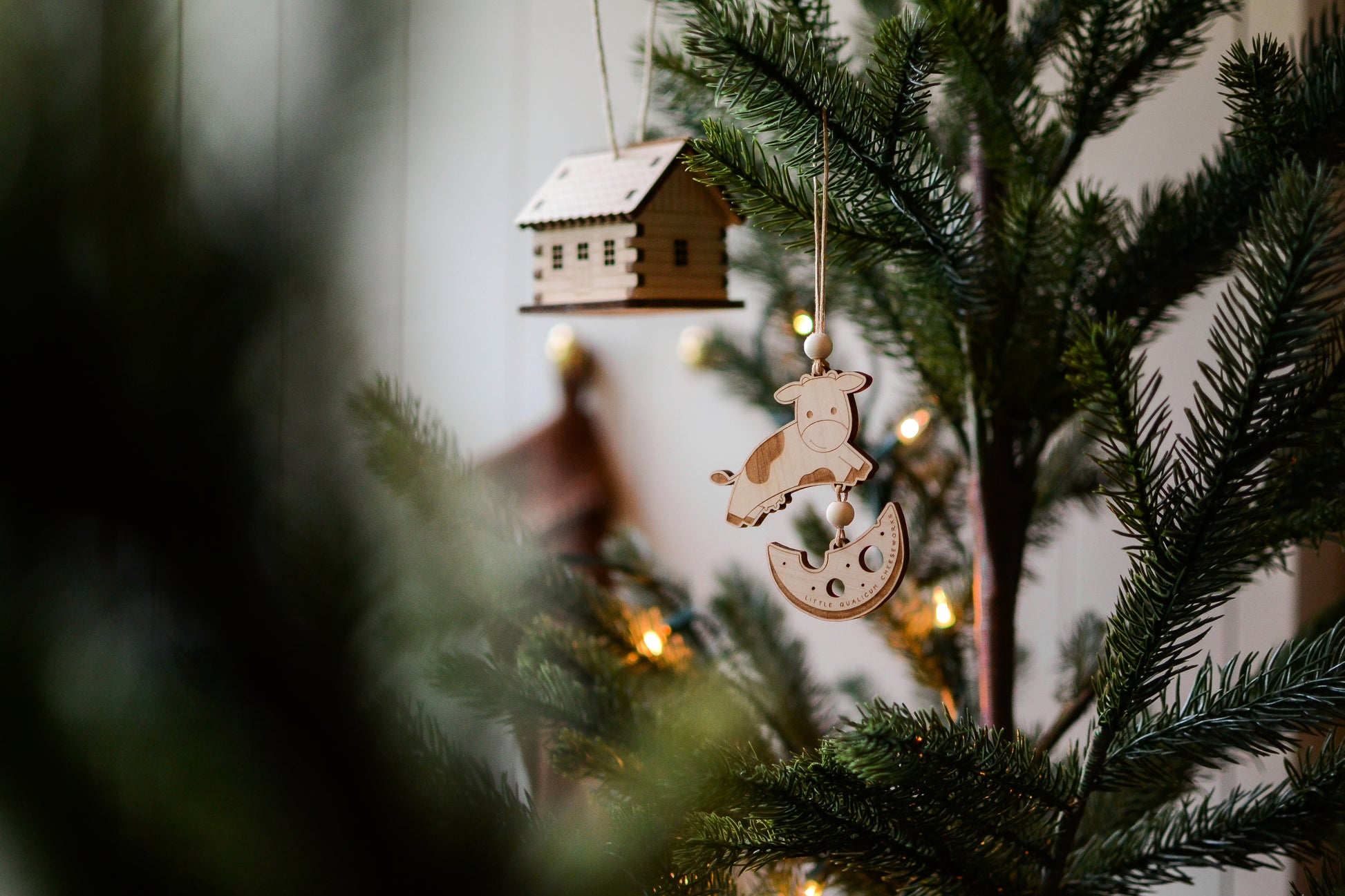 The wood ornament hangs on a Christmas tree.