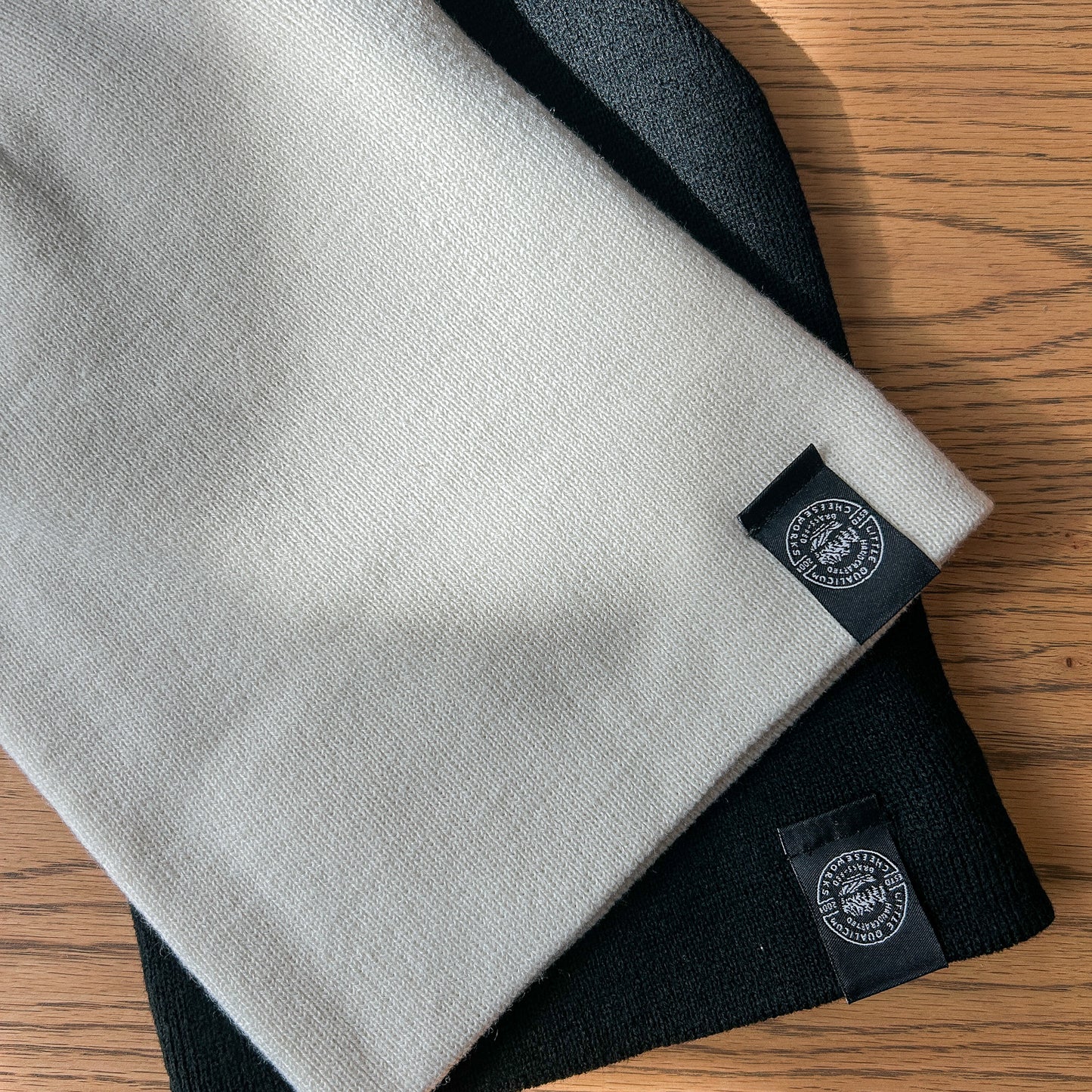 Toques with double-sided woven edge tag are shown with rim unrolled.